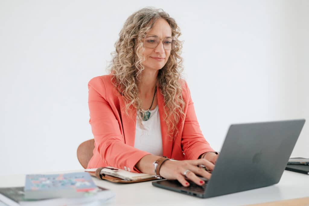 Susanne Rohrbeck am Laptop arbeitend am Tisch sitzend