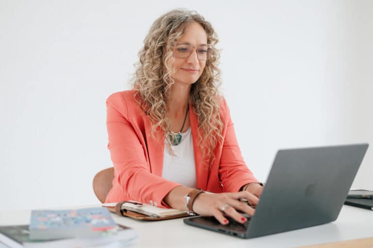 Susanne Rohrbeck am Laptop arbeitend am Tisch sitzend